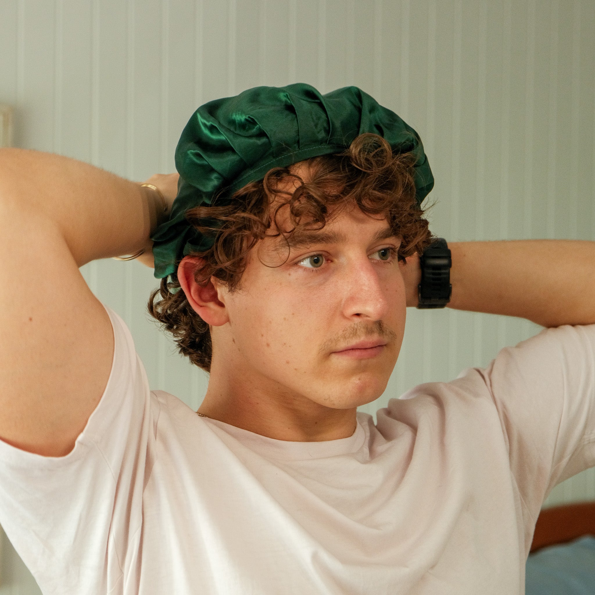 man trying on silk bonnet in dark green colour