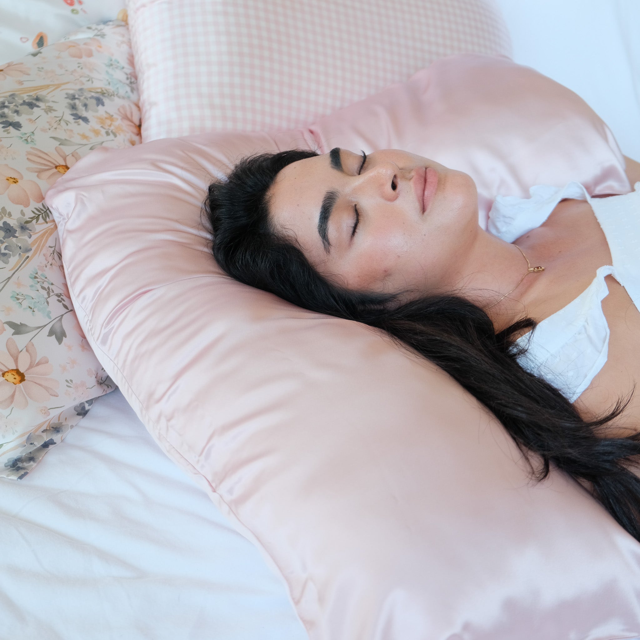 Close up of boomerang silk pillowcase in pink with model 